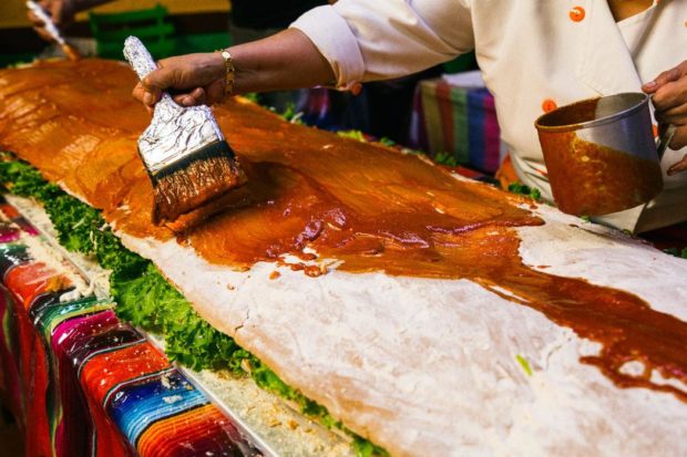 Bañando el pambazo con salsa de chile guajillo.