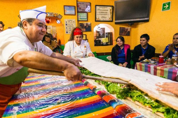Para que no se rompa el pan, los cocineros se ayudan de una pala que parece remo.